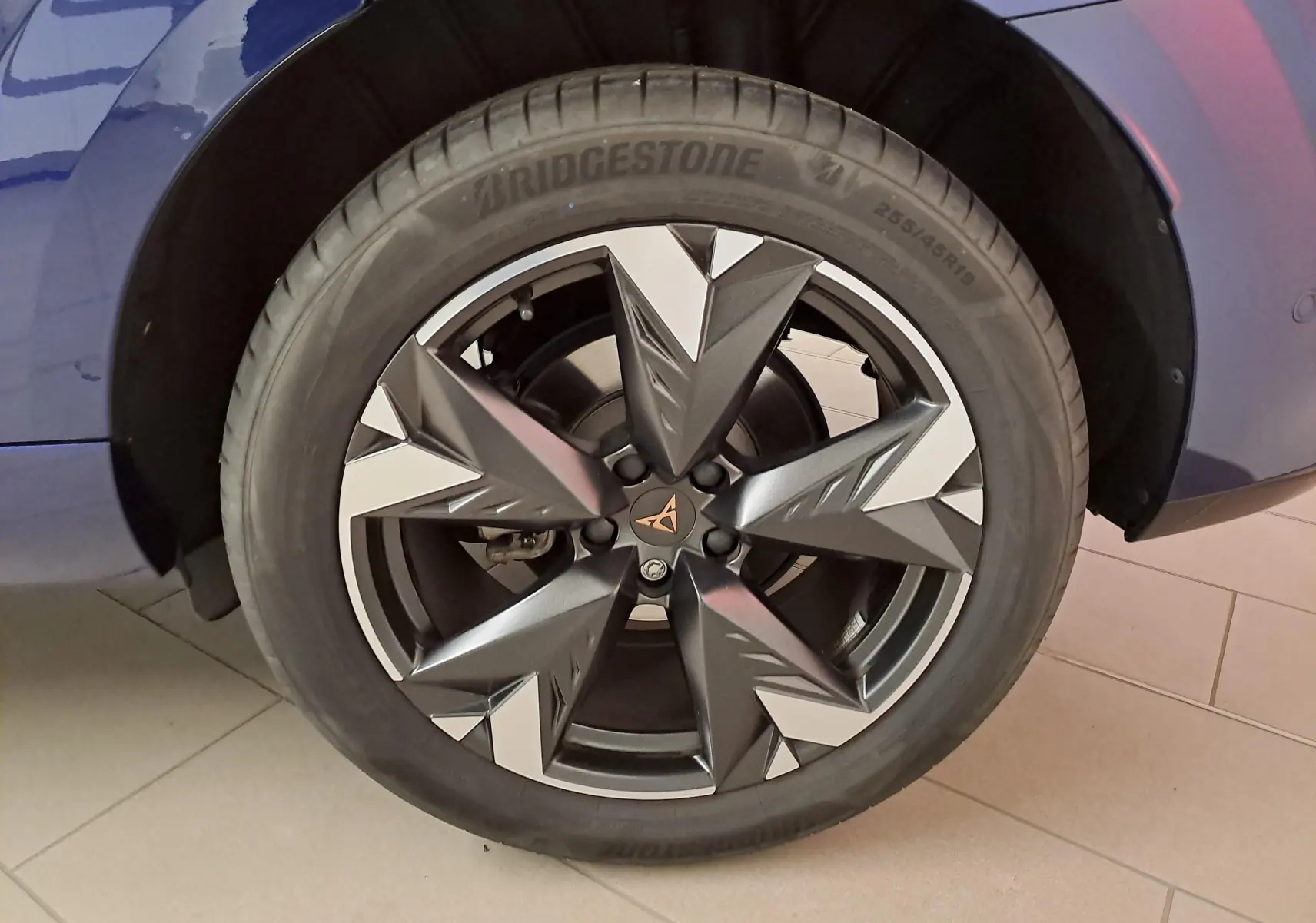 Gros plan sur la jante 19'' Spectrum usinée du côté gauche d'une CUPRA TERRAMAR Bleu Cosmos, avec pneu Bridgestone.