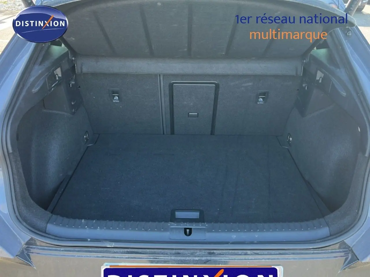 Coffre ouvert vu de l'arrière d'un CUPRA Formentor gris magnétique 2025, espace de chargement vide et tapis noir.