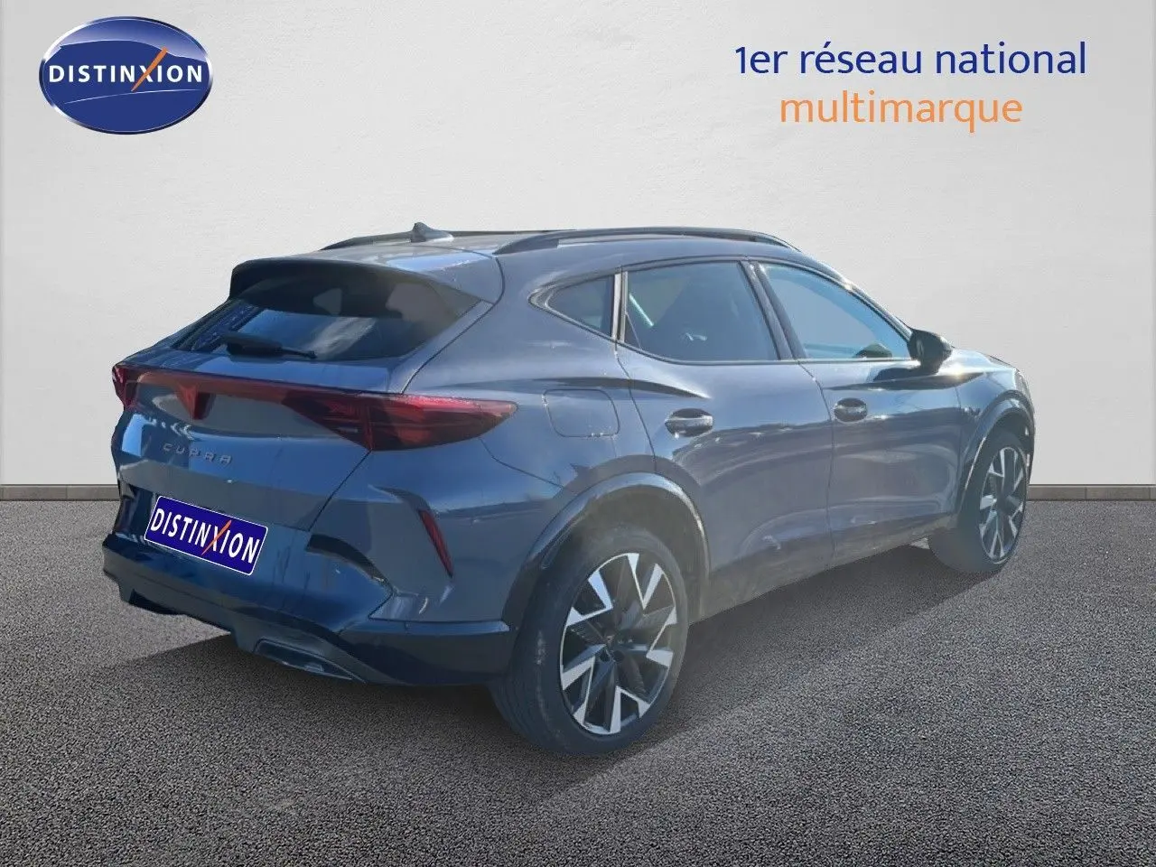 Vue 3/4 arrière droite d'un CUPRA Formentor gris magnétique métallisé avec jantes bi-ton et feux LED distinctifs.