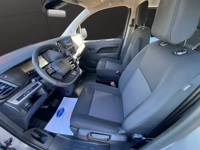 Vue intérieure côté conducteur du Peugeot Expert XL gris acier, montrant les sièges tissu bi-ton et le tableau de bord moderne.