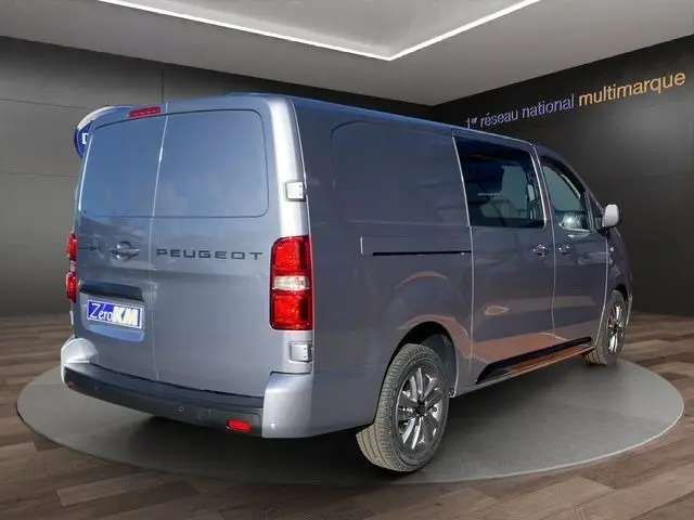 Vue 3/4 arrière droite du Peugeot Expert Cabine Approfondie gris acier avec jantes alliage et portes latérales fermées.