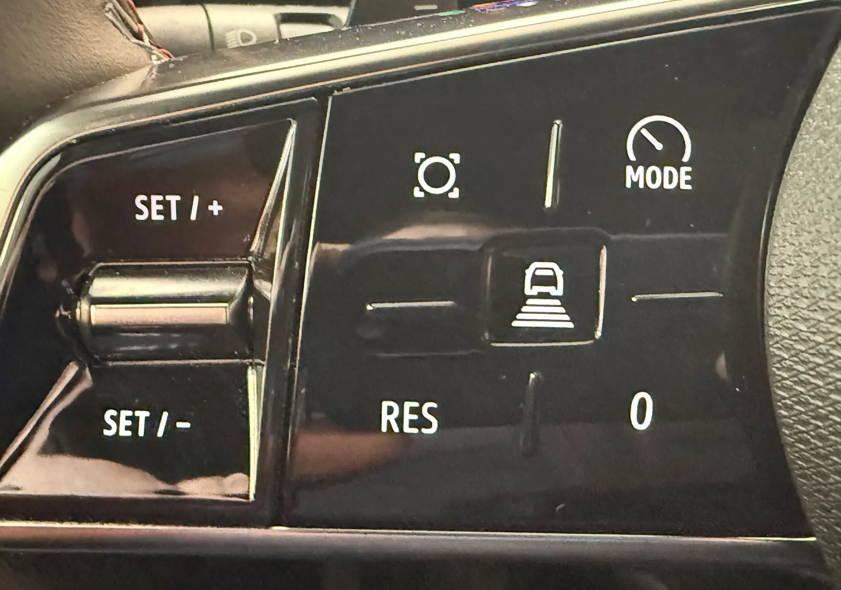 Gros plan sur les commandes au volant noir du Renault Espace VI E-Tech 200 Esprit Alpine, boutons de régulateur et mode.