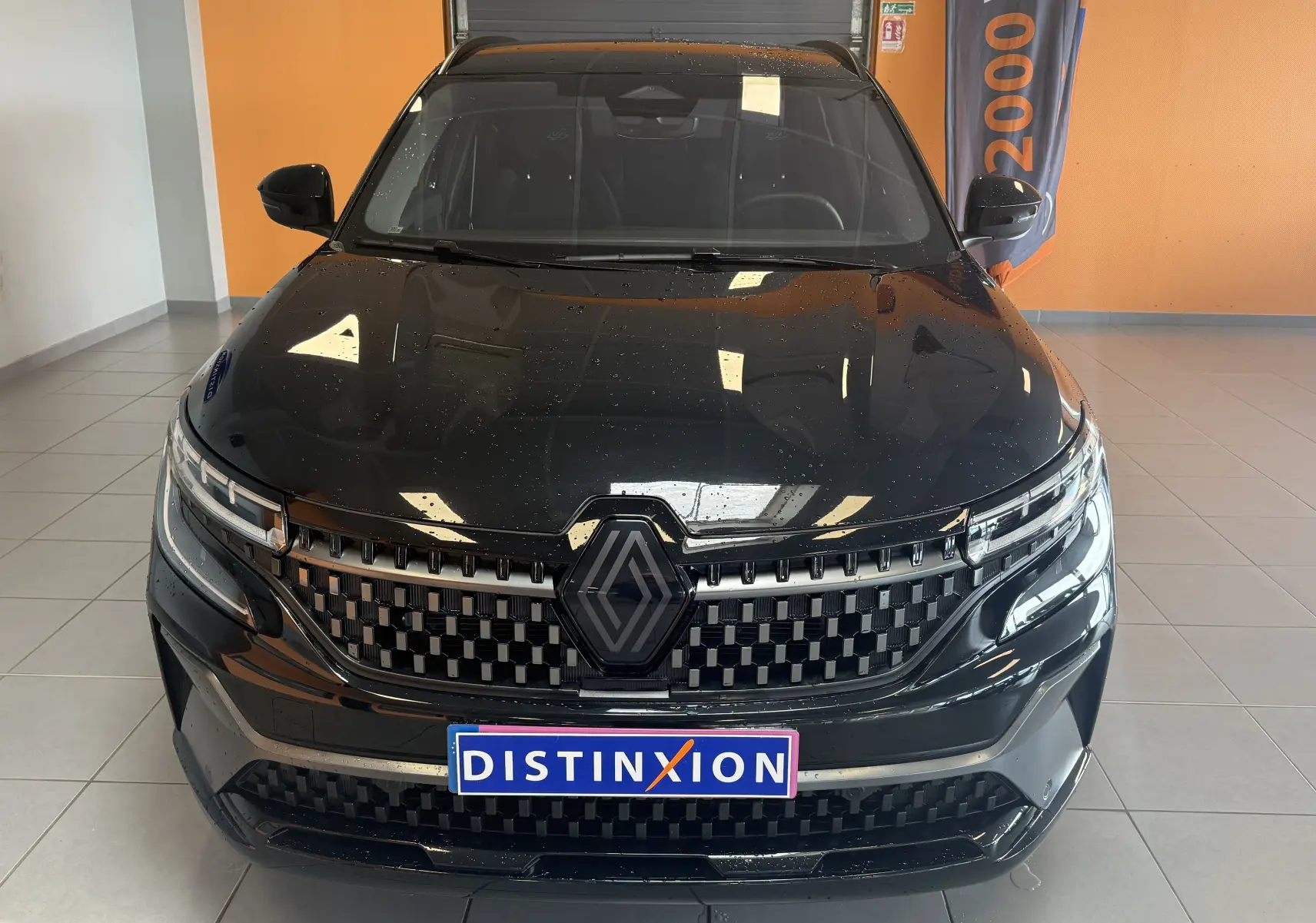 Vue avant rapprochée du Renault Espace VI E-Tech 200 Esprit Alpine noir avec calandre distinctive et logo central.