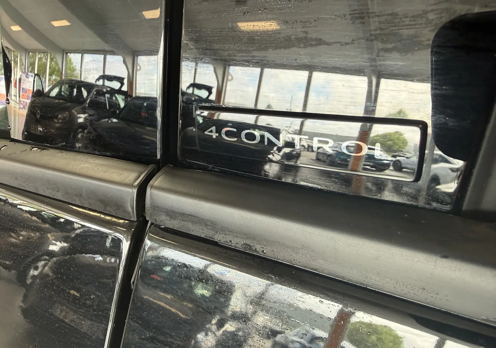 Gros plan sur le logo 4CONTROL sur la porte arrière noire du Renault Espace VI E-TECH 200 Esprit Alpine.