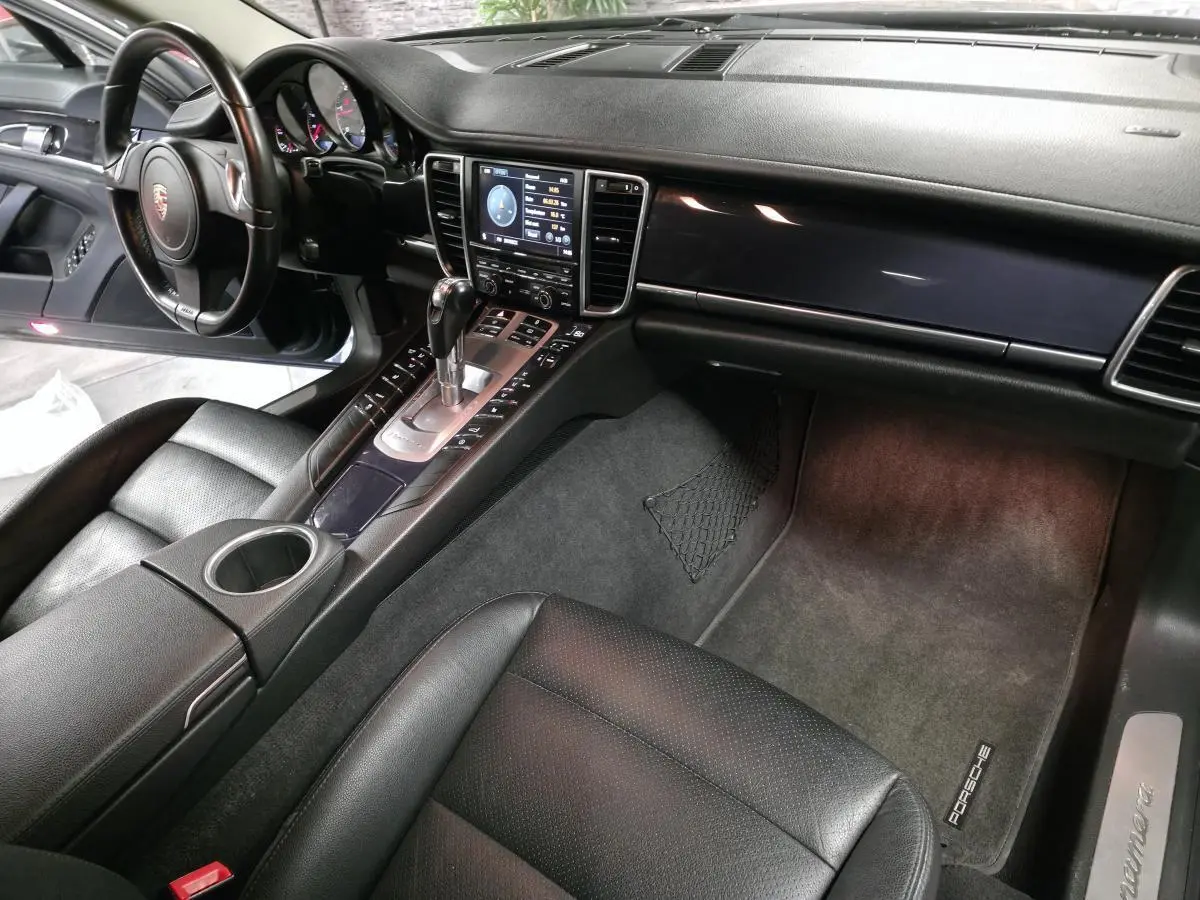 Intérieur noir cuir de Porsche Panamera 2011 vu côté passager avec console centrale et tableau de bord.