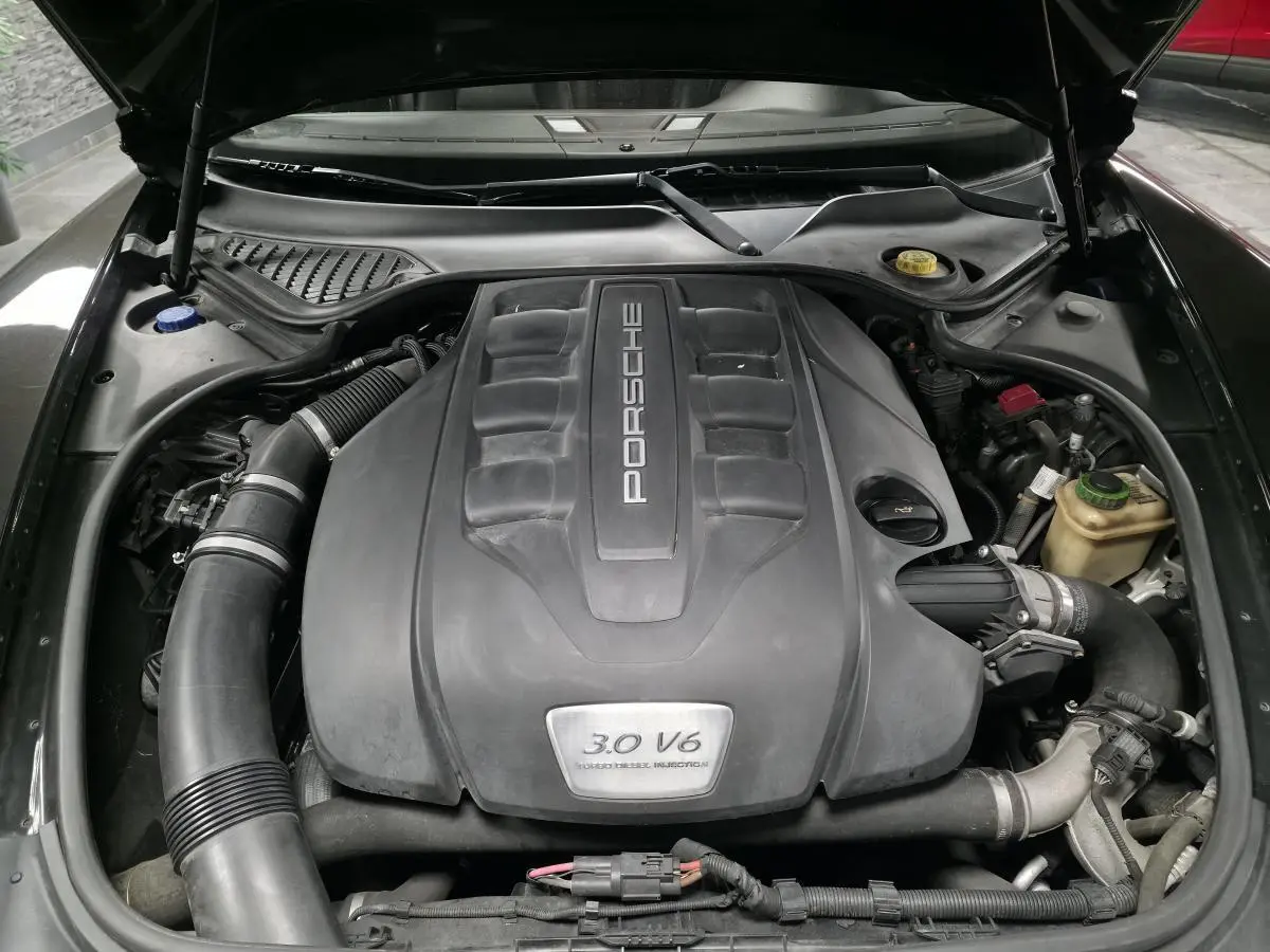Moteur 3.0 V6 Porsche Panamera diesel vu de dessus sous le capot ouvert, avec cache moteur noir.