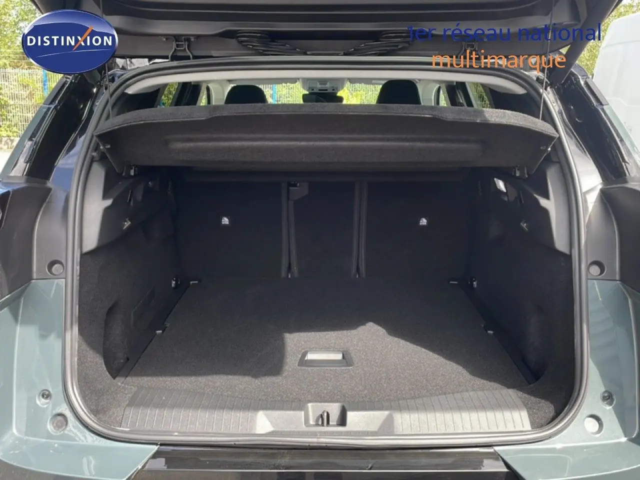 Coffre ouvert vu de l'arrière d'un Citroën C5 Aircross Hybrid vert Astoria Metal, montrant l'espace de chargement vide.