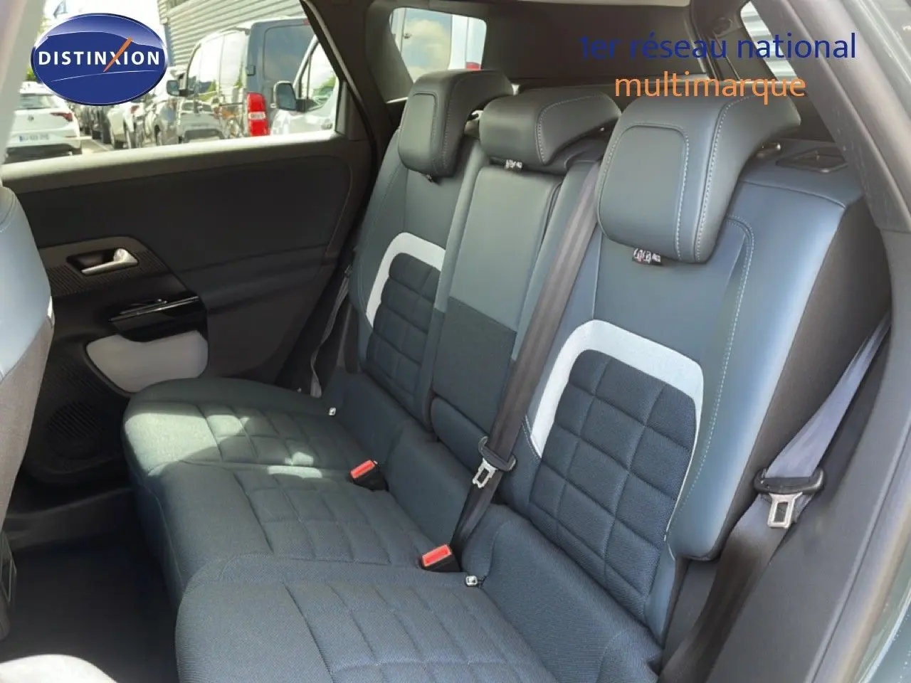 Vue intérieure de la banquette arrière du Citroën C5 Aircross Hybrid, avec sellerie tissu et cuir noir aux surpiqûres blanches.