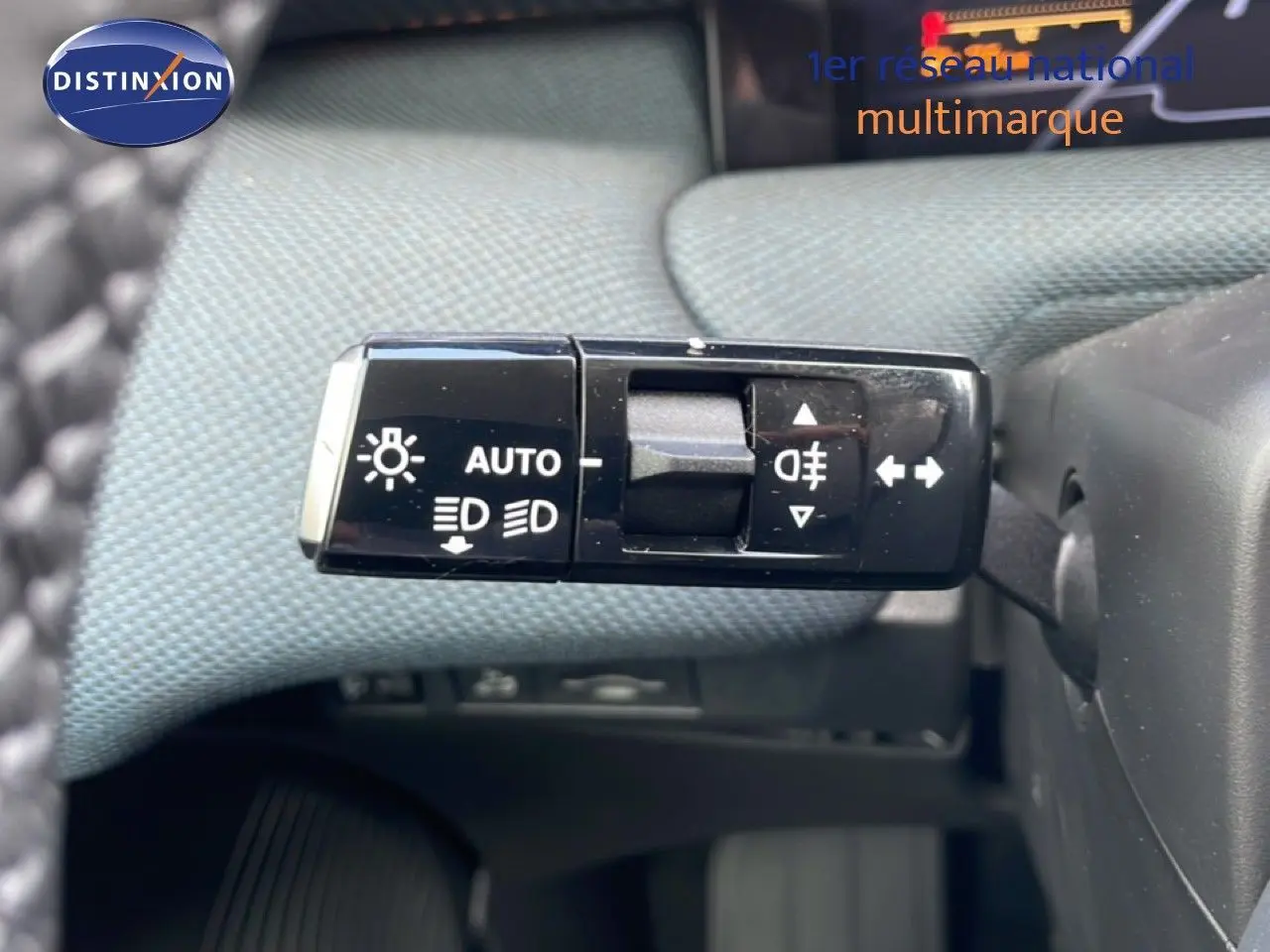 Gros plan sur la commande des phares et clignotants du Citroën C5 Aircross Hybrid, intérieur tissu gris.