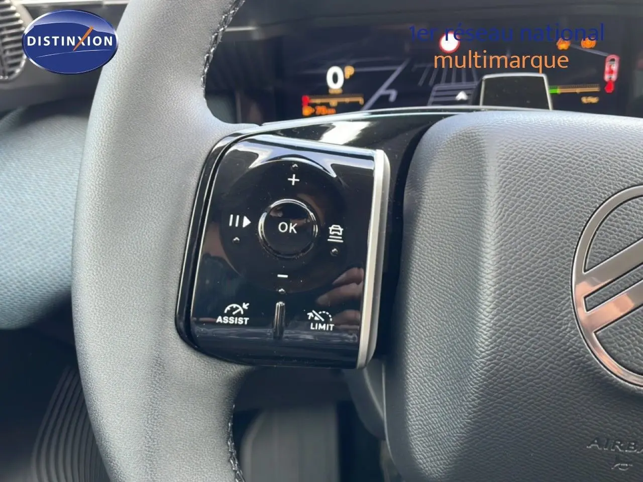 Gros plan sur le volant du Citroën C5 Aircross Hybrid vert Astoria, avec commandes intégrées et tableau de bord numérique en arrière-plan.
