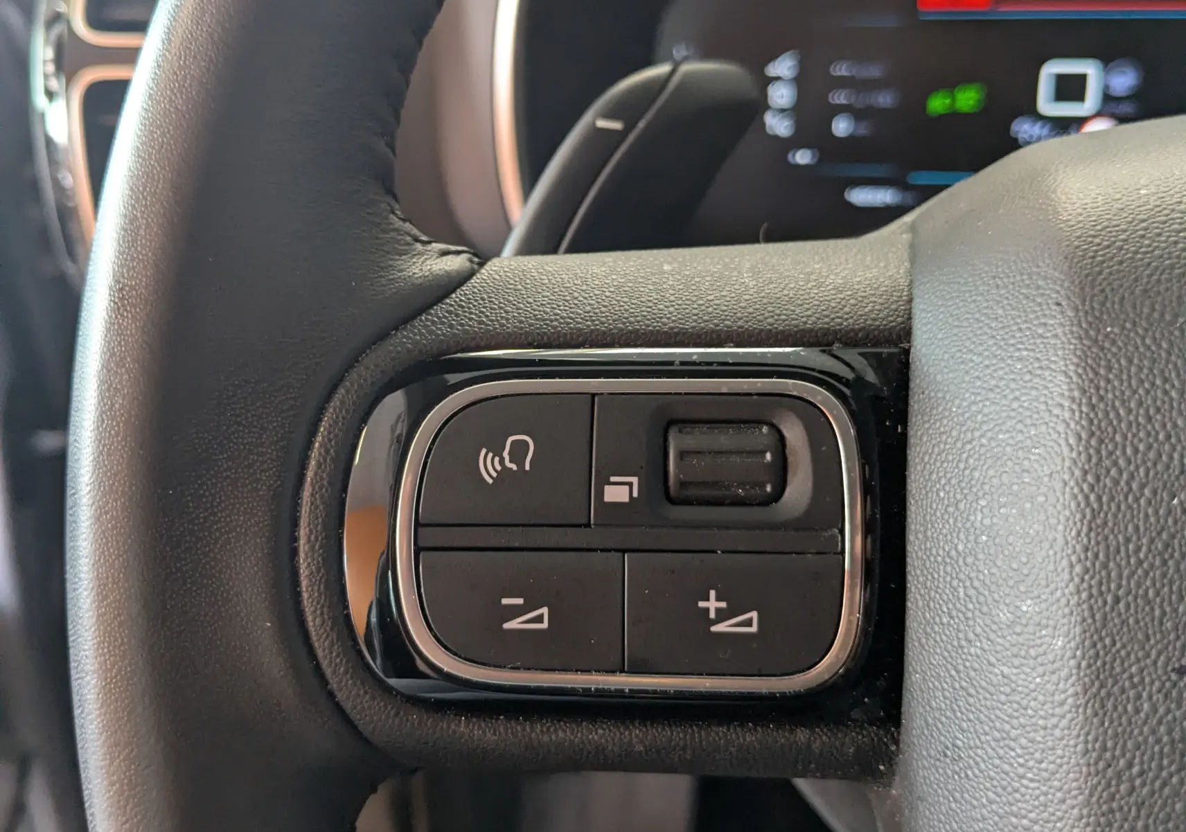 Gros plan sur les commandes vocales et volume au volant noir du Citroën C5 Aircross 2024, finition Alcantara.