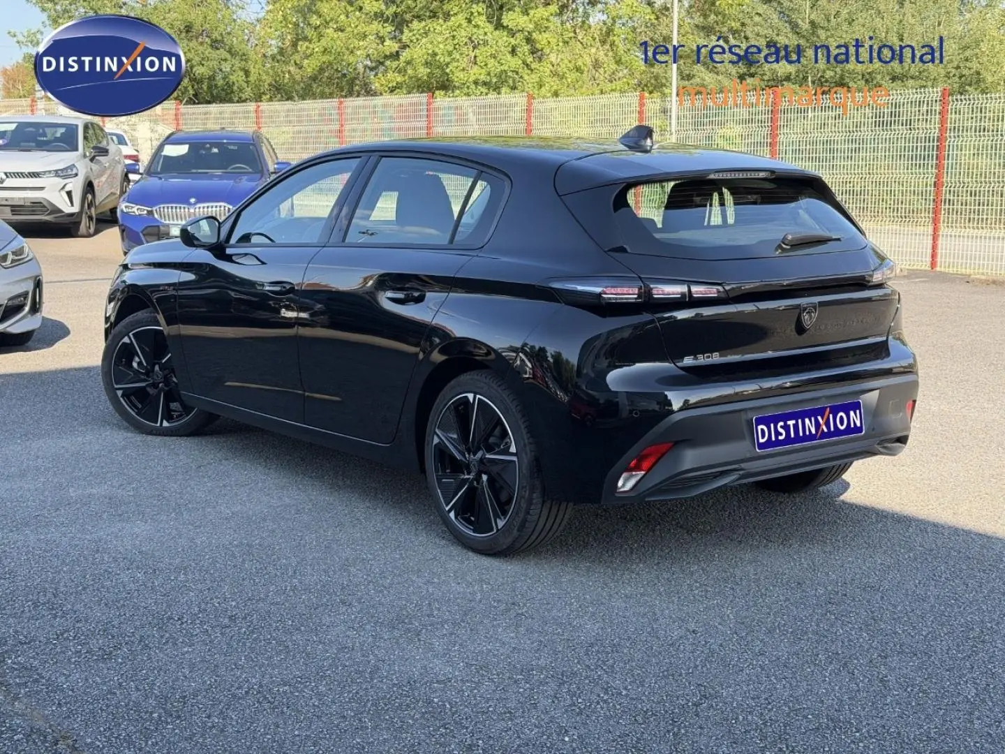 Vue 3/4 arrière droite d'une Peugeot e-308 noire Perla Nera avec jantes alliage et feux arrière LED distinctifs.