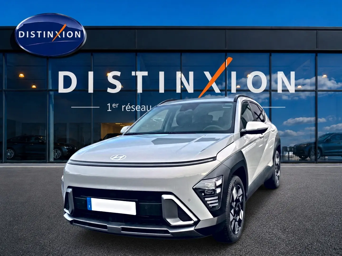 Hyundai Kona gris 2025 en 3/4 avant droit, avec calandre épurée et jantes alliage 18 pouces visibles.