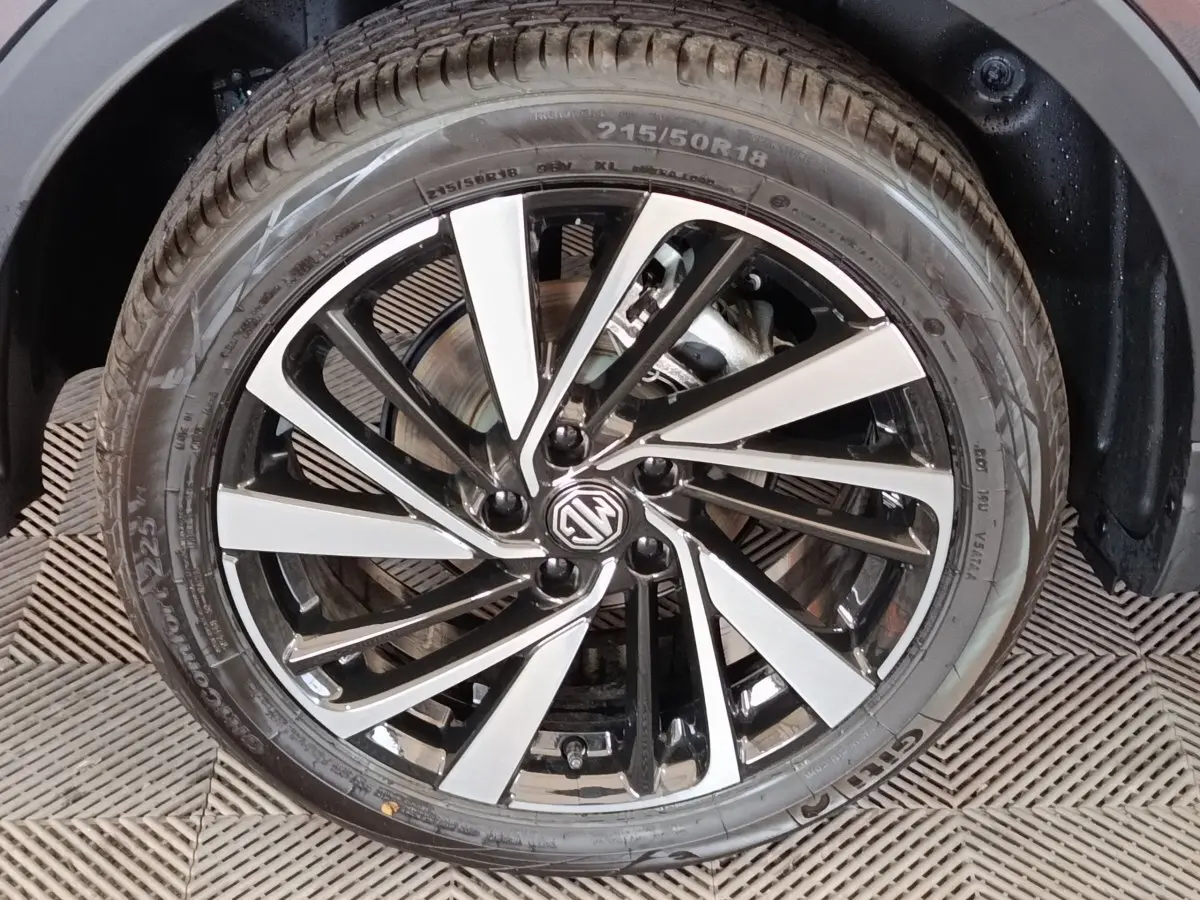 Gros plan sur la roue avant droite du MG ZS gris foncé, jante alliage bicolore au design moderne.