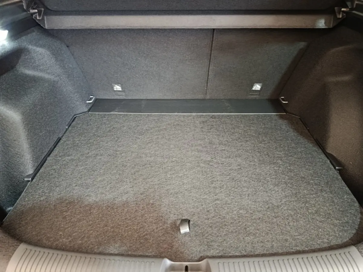 Coffre spacieux et vide du MG Motor ZS 1.5L Hybrid+ Luxury gris foncé, vue intérieure depuis l'arrière ouverte.