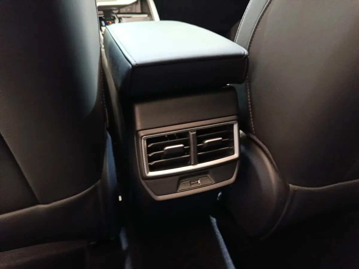 Vue rapprochée de l'accoudoir central arrière noir avec bouches d'aération et port USB du MG Motor ZS hybride 2026.