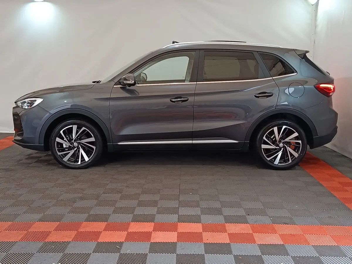 Profil droit du MG ZS gris foncé 2026 avec jantes alliage noires et toit ouvrant panoramique visible.