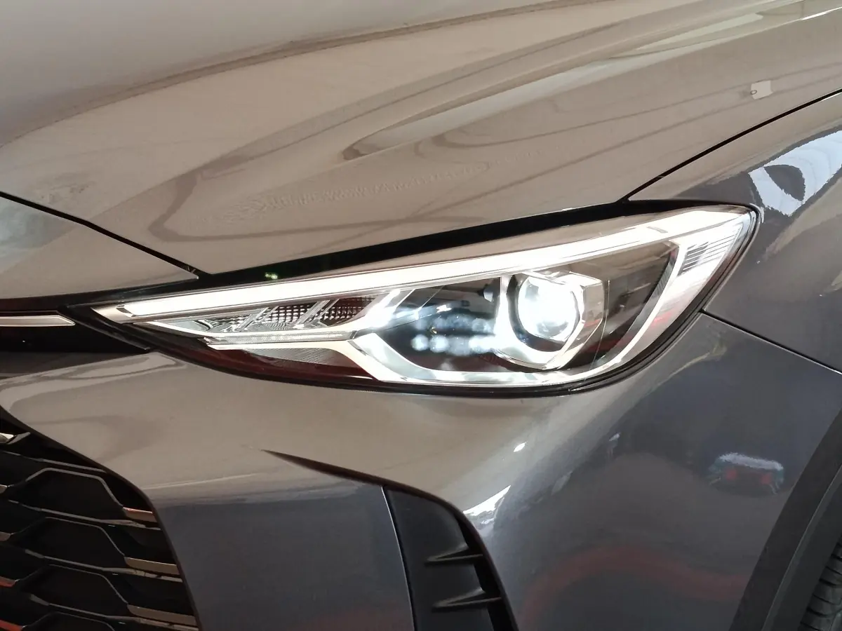 Gros plan sur le phare avant droit du MG MOTOR ZS gris foncé, mettant en valeur son design LED moderne.