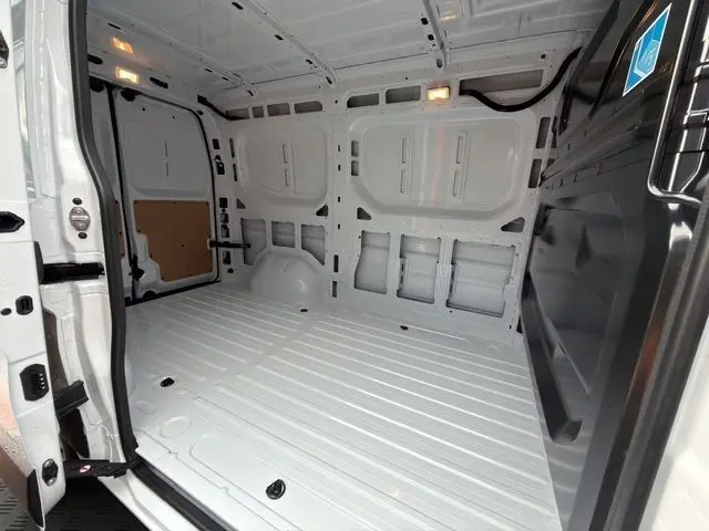 Vue intérieure arrière du Renault Master blanc 2025, montrant l’espace de chargement tôlé et éclairage LED au plafond.