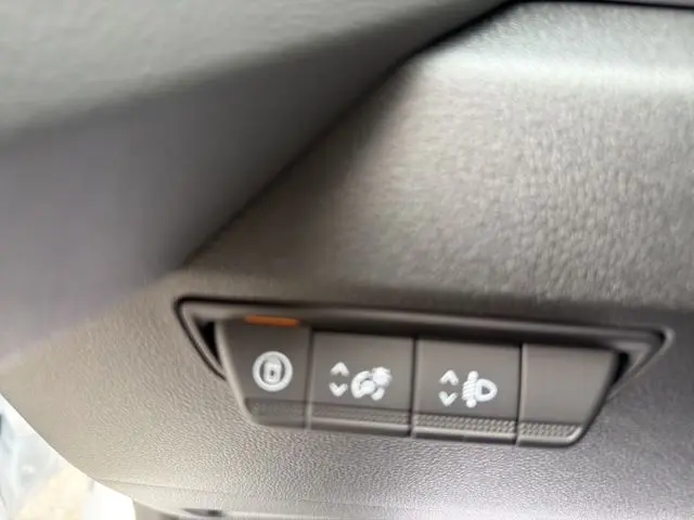 Gros plan sur les commandes d'éclairage et frein de stationnement du Renault Master blanc, vue intérieure.