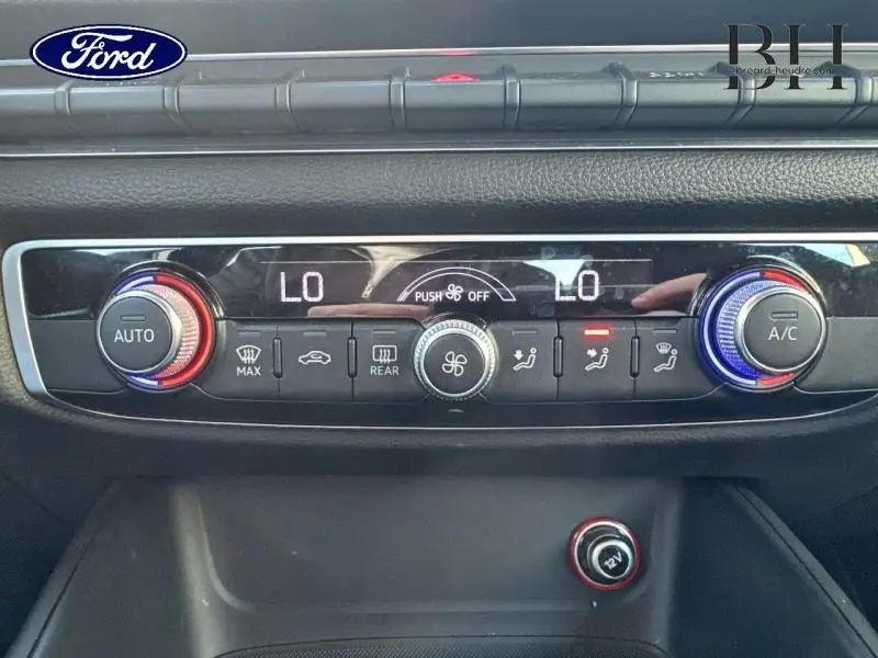 Panneau de commande de climatisation de l'Audi A3 Sportback 2016, vue frontale, avec réglages numériques et boutons rotatifs colorés.