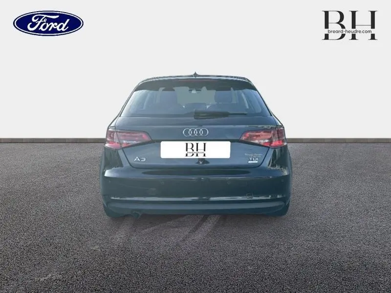 Vue arrière d'une Audi A3 Sportback noire brillante de 2016 avec logo TDI et hayon fermé sur sol gris.