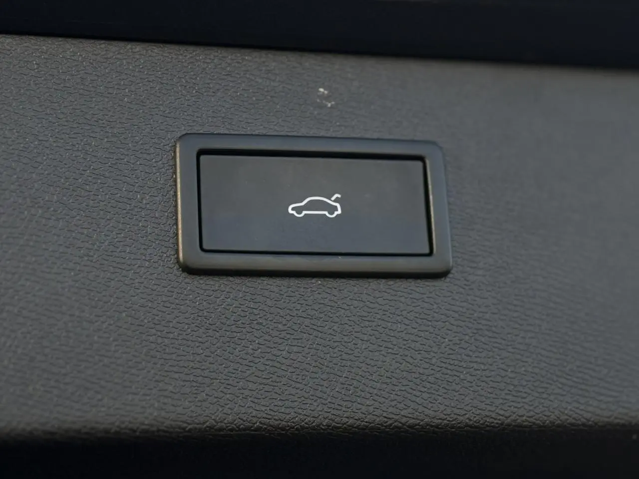 Bouton d'ouverture du hayon sur la garniture intérieure grise d'un CUPRA Formentor 2025.