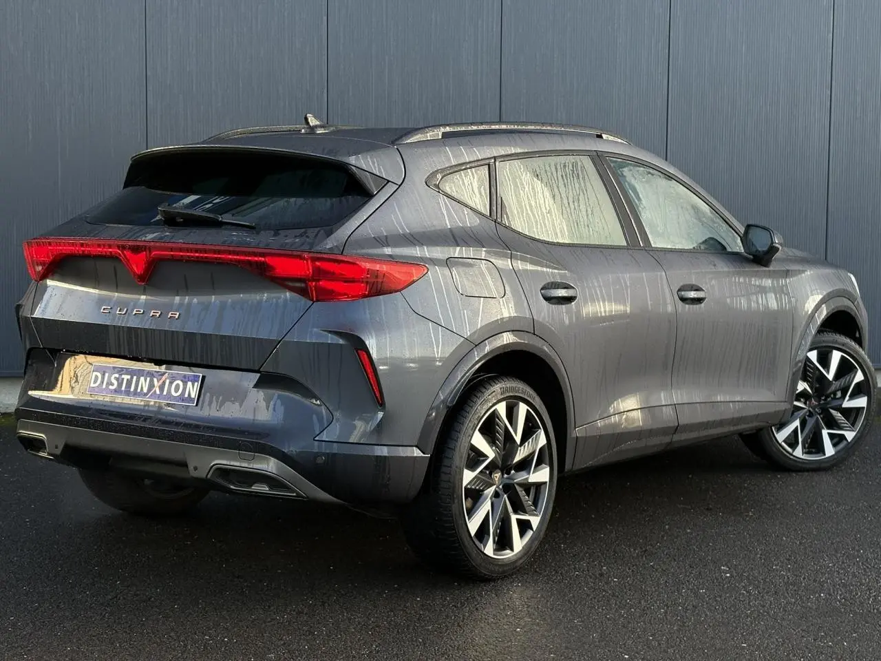 Vue 3/4 arrière droite d'une CUPRA Formentor blanche avec feux arrière LED et jantes alliage distinctives.