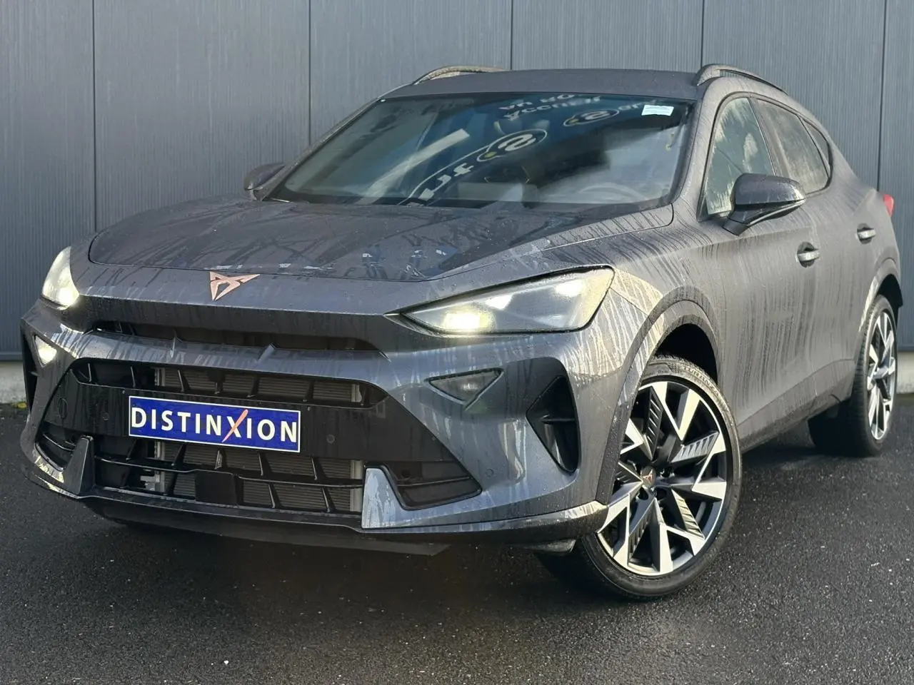 Vue 3/4 avant droite d'une CUPRA Formentor blanche avec jantes alliage noires et calandre marquée.