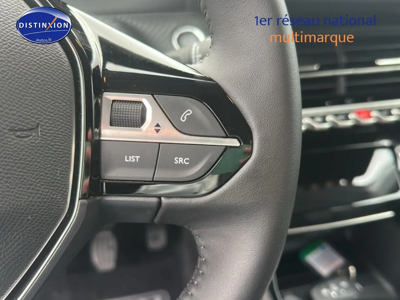 Gros plan sur les commandes au volant en cuir noir de la Peugeot 208 1.2 PureTech 100 Allure 2024.