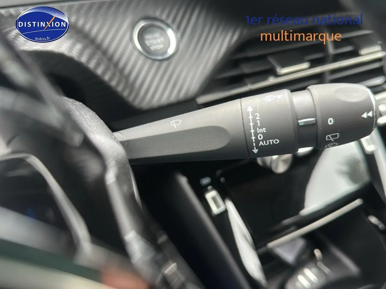 Gros plan sur la commande d’essuie-glace côté gauche du tableau de bord d’une Peugeot 208 gris Artense 2024.