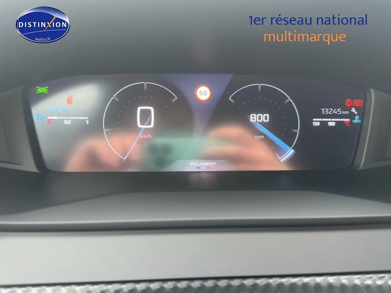 Tableau de bord numérique de Peugeot 208 2024 affichant vitesse, compte-tours et alertes, vue frontale rapprochée.