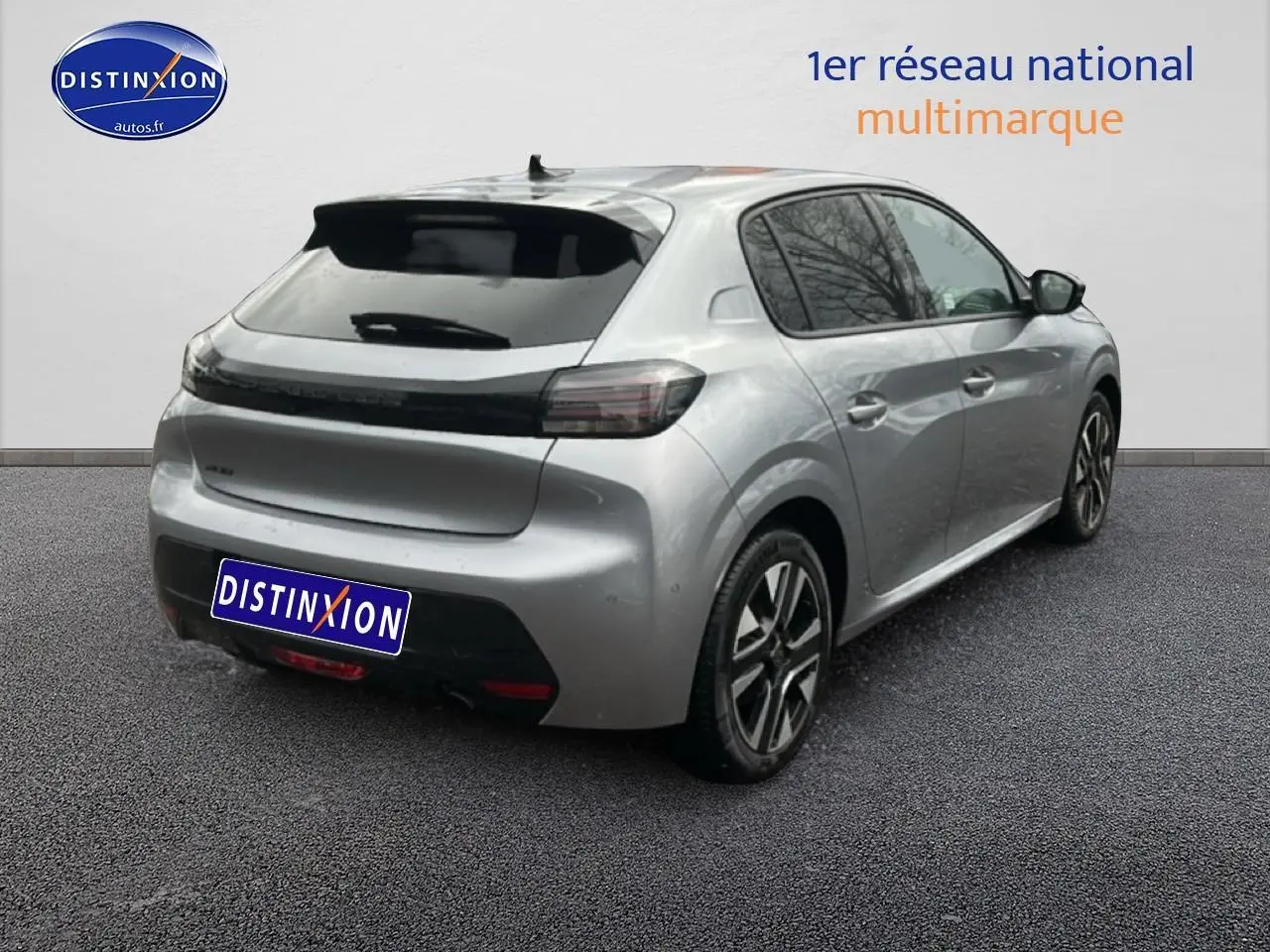 Vue 3/4 arrière droite d'une Peugeot 208 1.2 PureTech 100 Allure gris Artense avec jantes alu et vitres teintées.