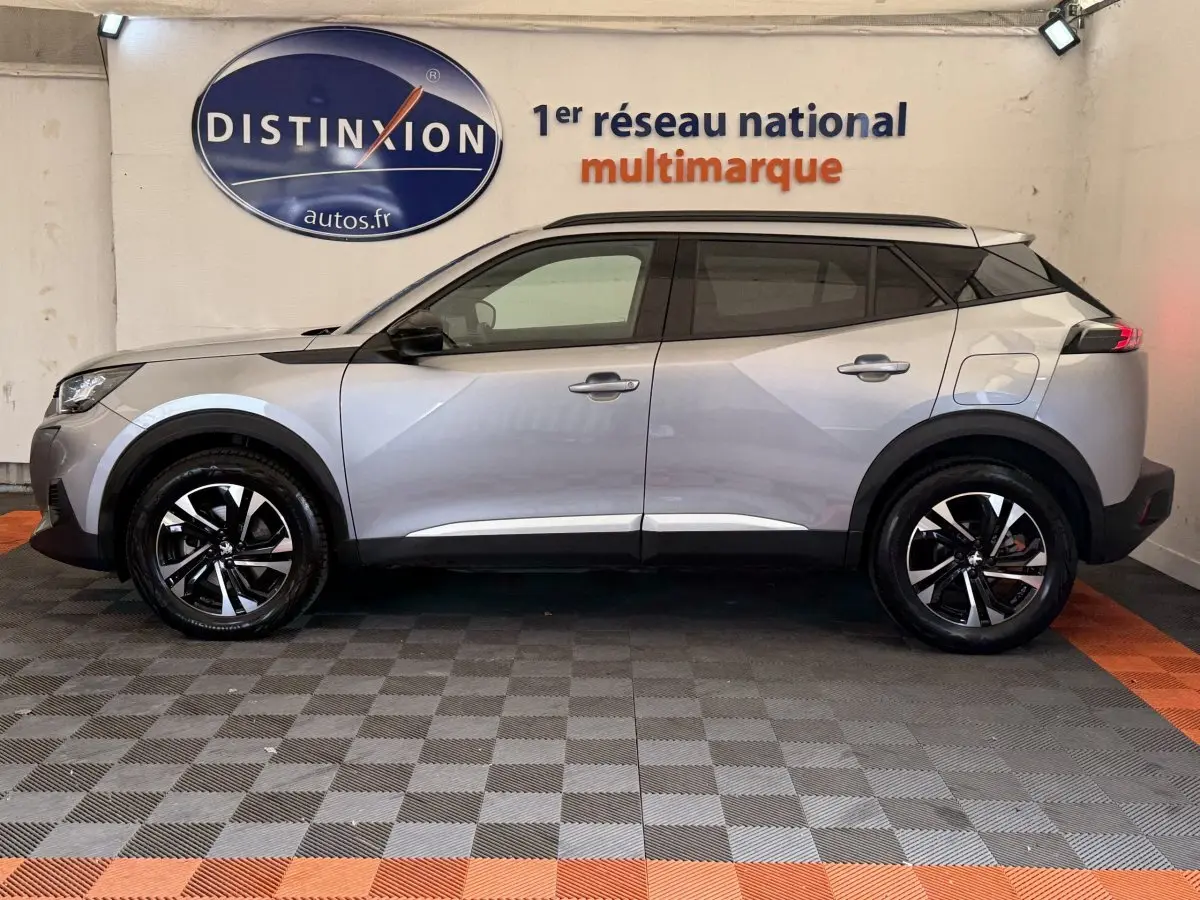 Peugeot 2008 gris clair vue de profil côté gauche, avec jantes noires et toit noir contrastant.