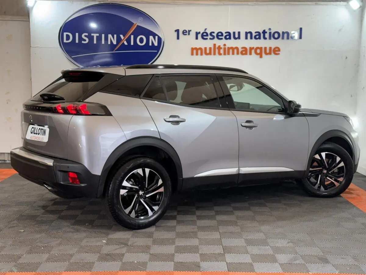 Peugeot 2008 gris clair vue de profil droit, mettant en valeur ses jantes noires et son toit noir contrastant.