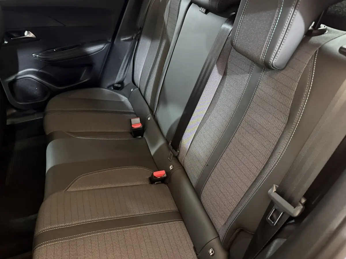 Vue intérieure sur la banquette arrière du Peugeot 2008 gris clair, avec ceinture et habillage tissu-cuir noir.