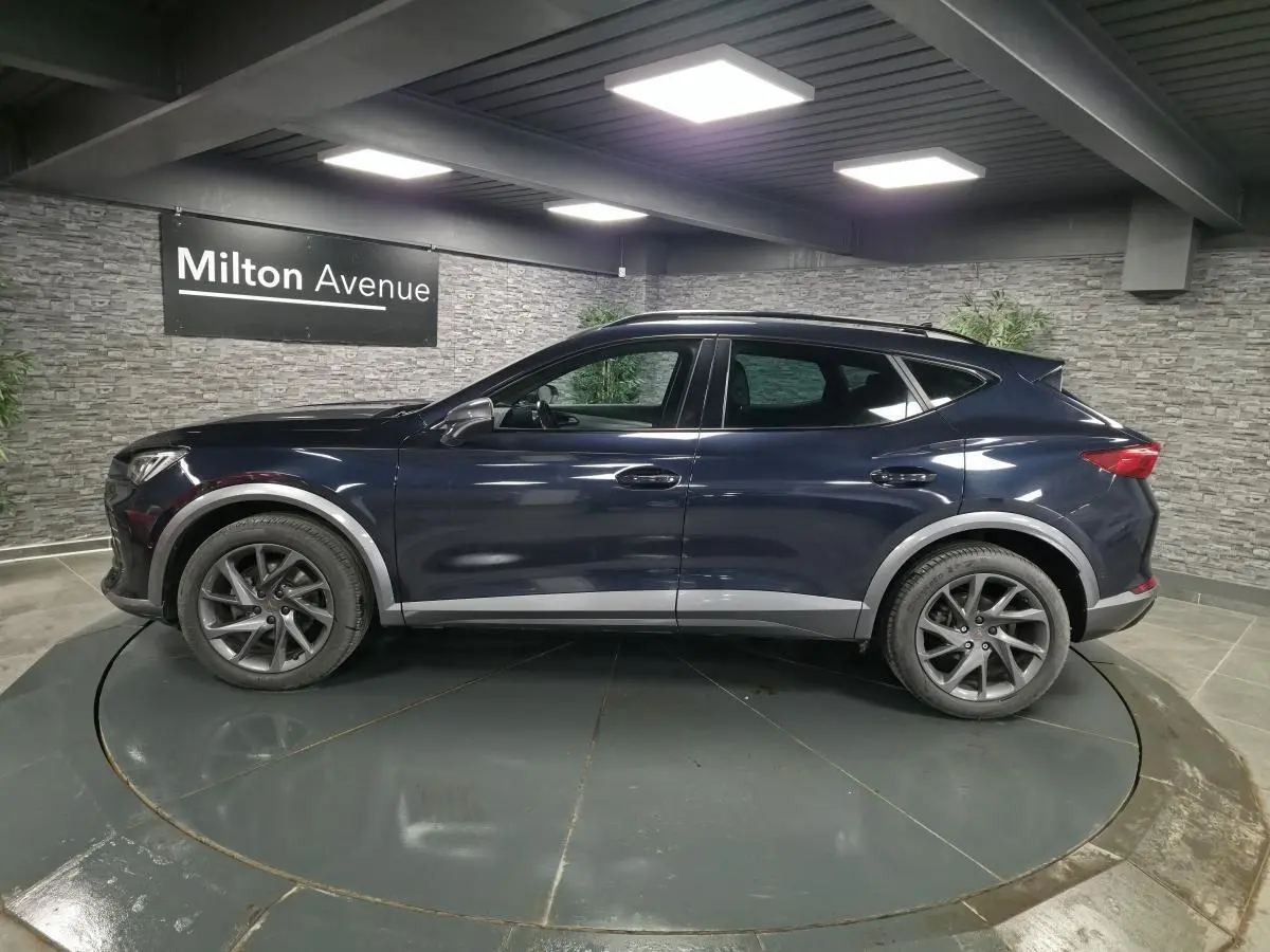 Vue latérale droite d'un CUPRA Formentor bleu avec jantes alliage 18 pouces et protections de bas de caisse grises.