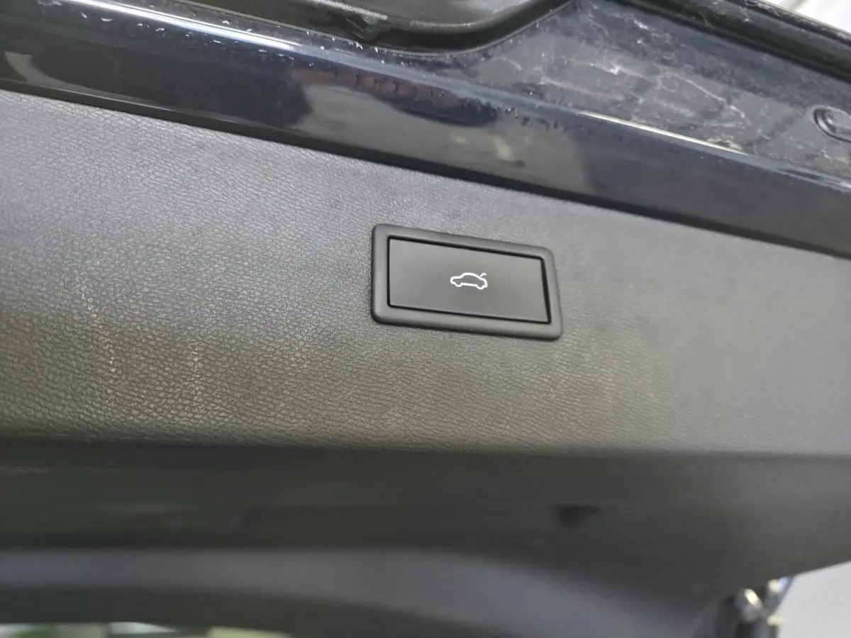 Bouton d'ouverture électrique du hayon sur la face intérieure du coffre d'une CUPRA Formentor bleu.