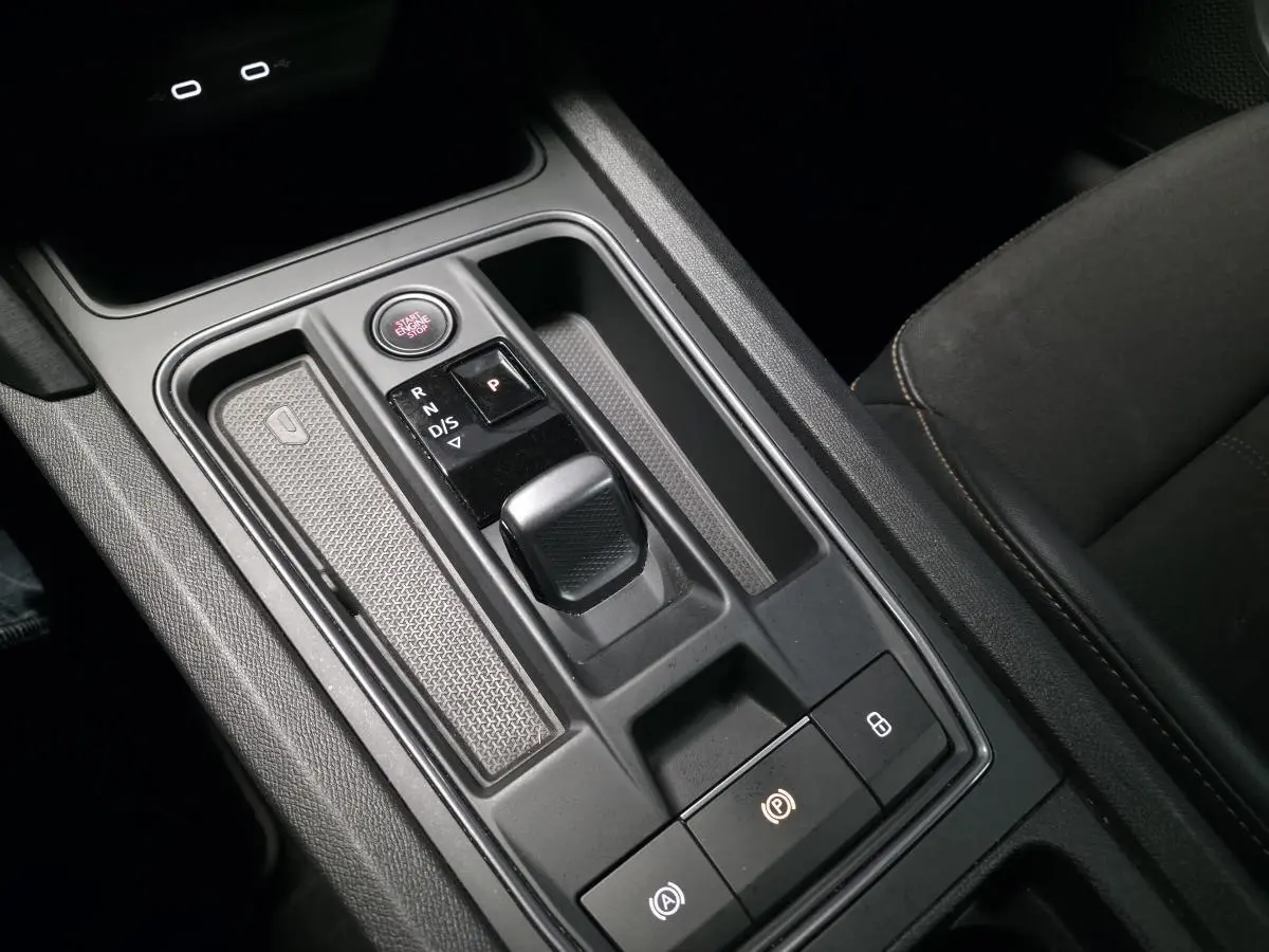 Vue rapprochée de la console centrale avec levier de vitesses automatique et bouton Start/Stop dans une CUPRA Formentor bleu.