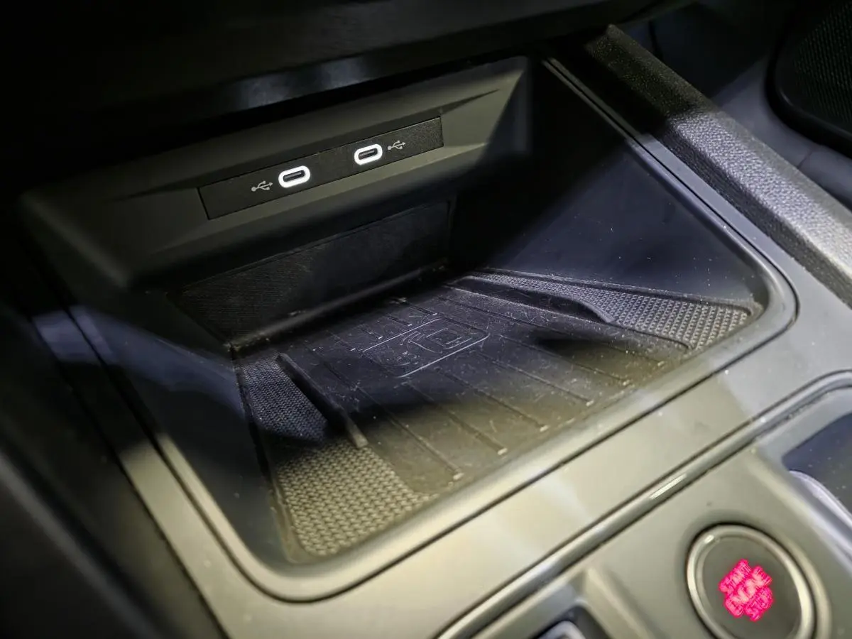 Gros plan sur la console centrale noire du CUPRA Formentor avec deux ports USB-C éclairés et un espace de rangement.