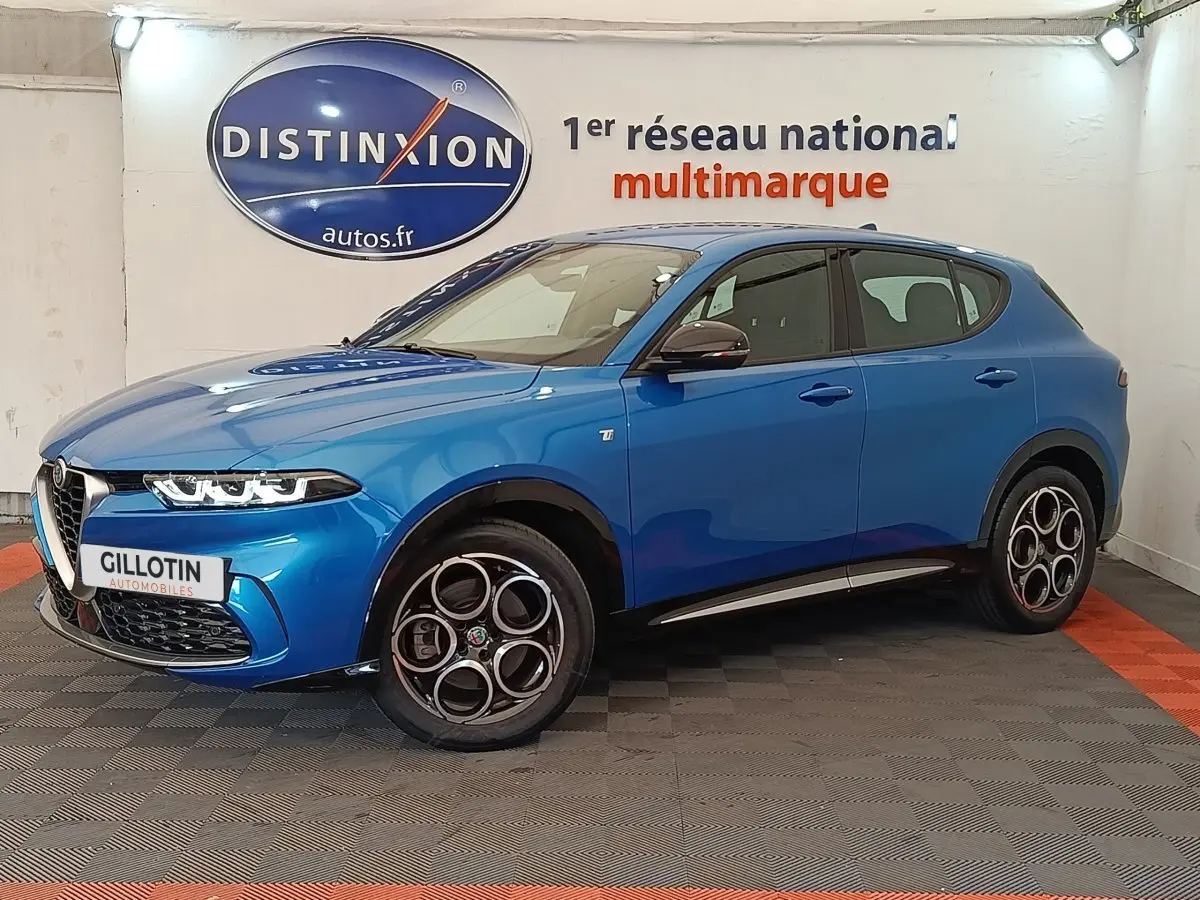 Vue 3/4 avant gauche d'une Alfa Romeo Tonale 1.5T Hybrid 160 VGT bleu avec jantes distinctives à cercles entrelacés.