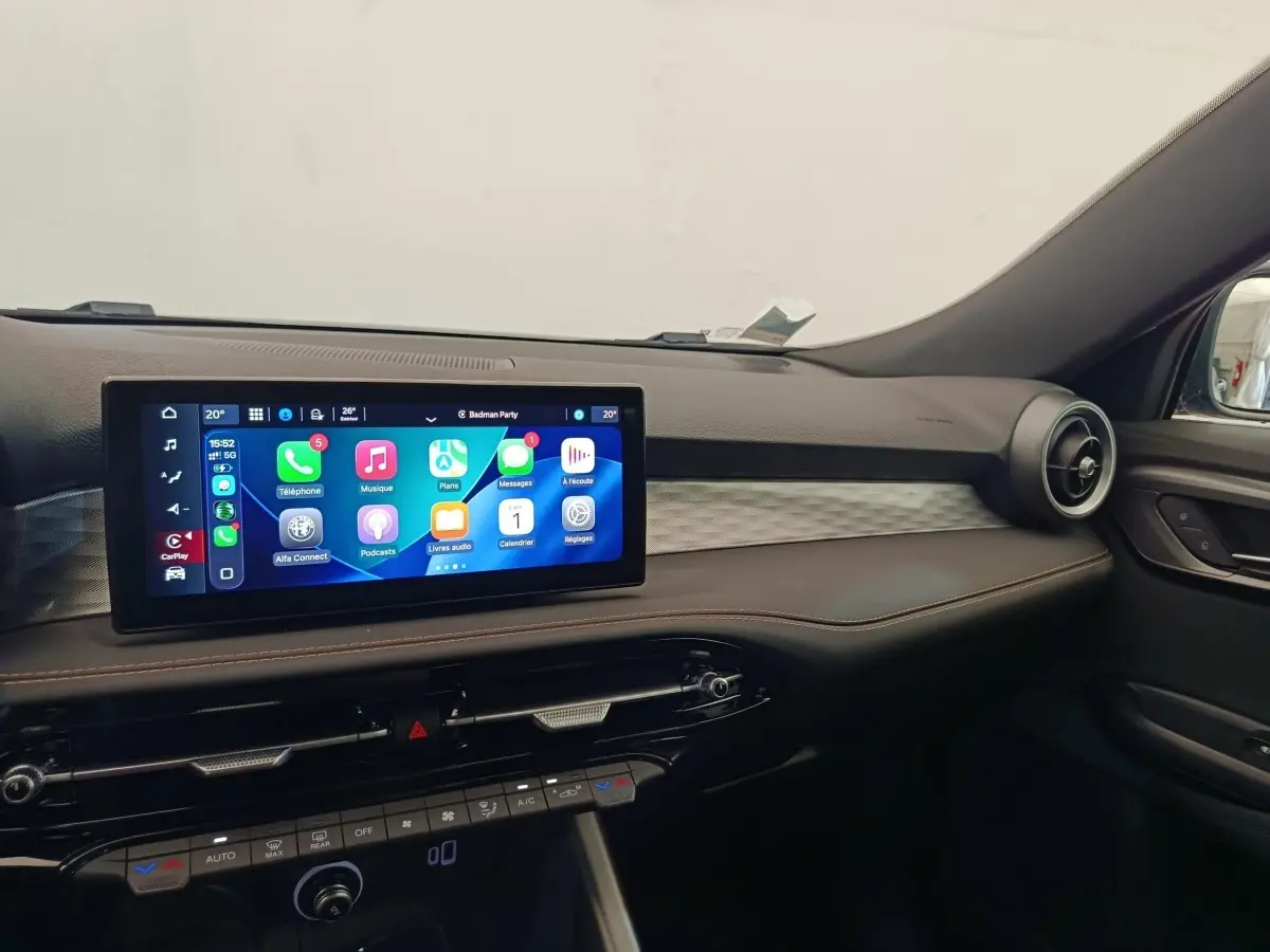 Vue intérieure du tableau de bord de l'Alfa Romeo Tonale 1.5T Hybrid 2023 avec écran tactile central et finitions noires.