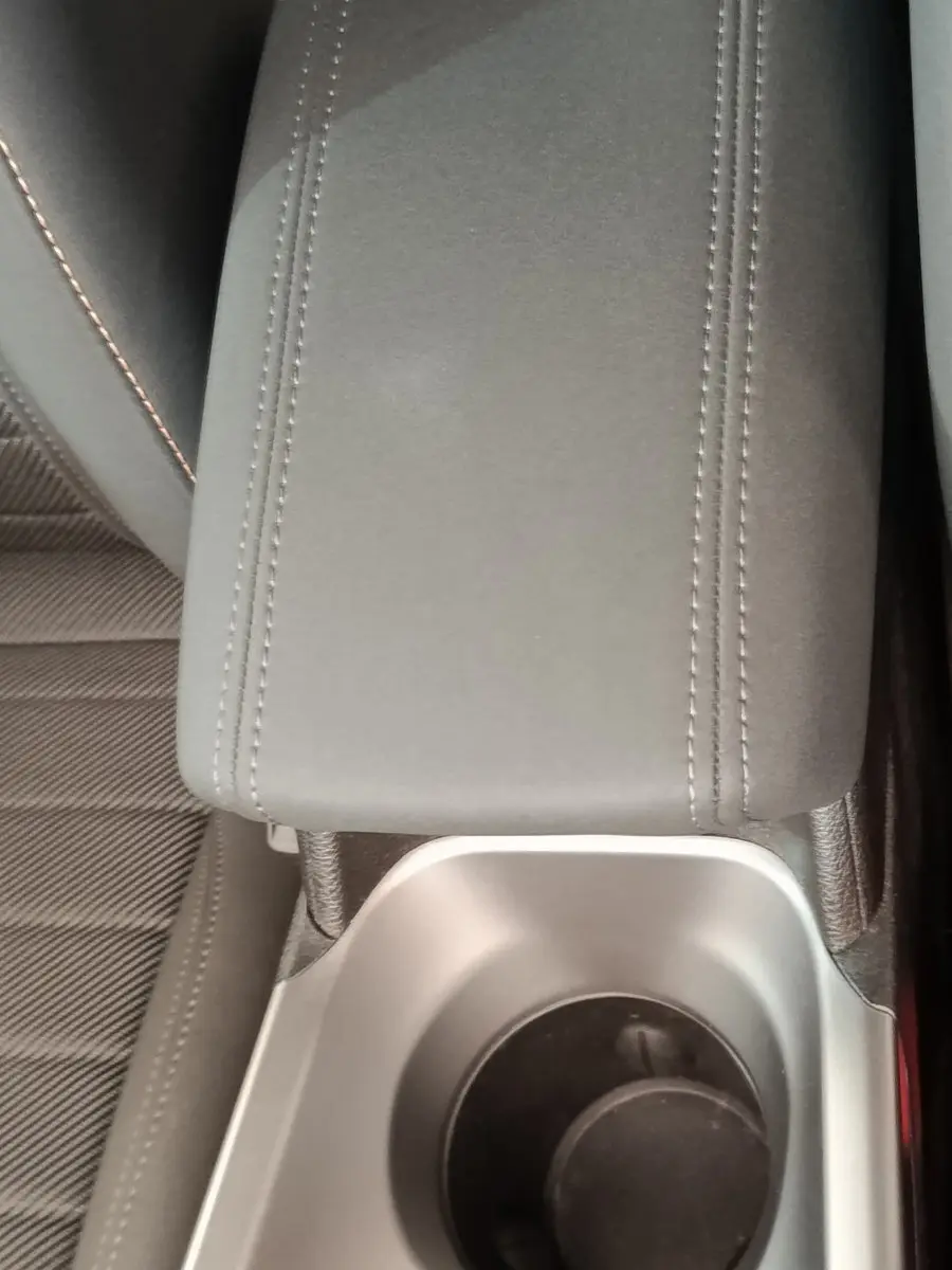 Gros plan sur l'accoudoir central gris et porte-gobelet de l'intérieur d'une Alfa Romeo Tonale 2023.