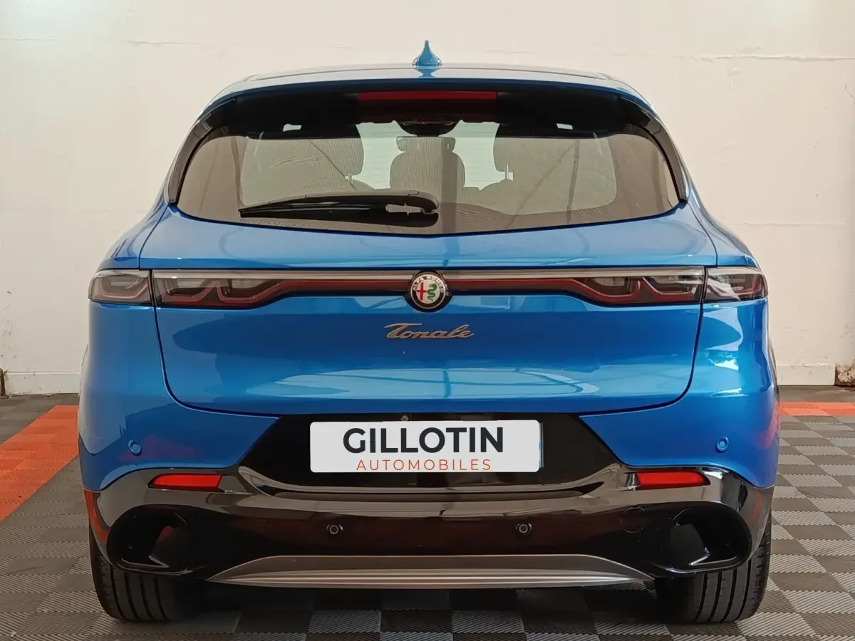 Vue arrière de l'Alfa Romeo Tonale bleu 2023 avec feux LED reliés et double sortie d'échappement noire.