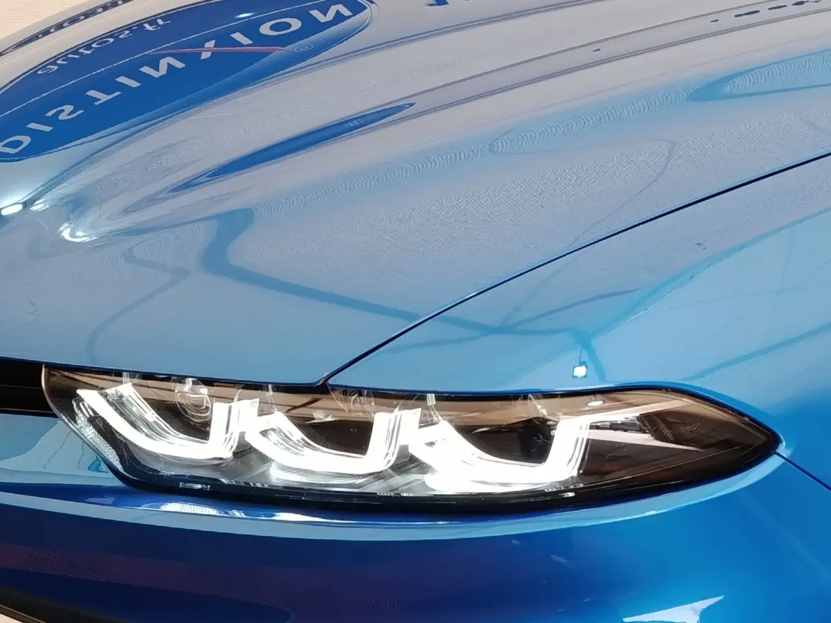 Gros plan sur le phare avant LED d'un Alfa Romeo Tonale bleu, soulignant le design distinctif et moderne.