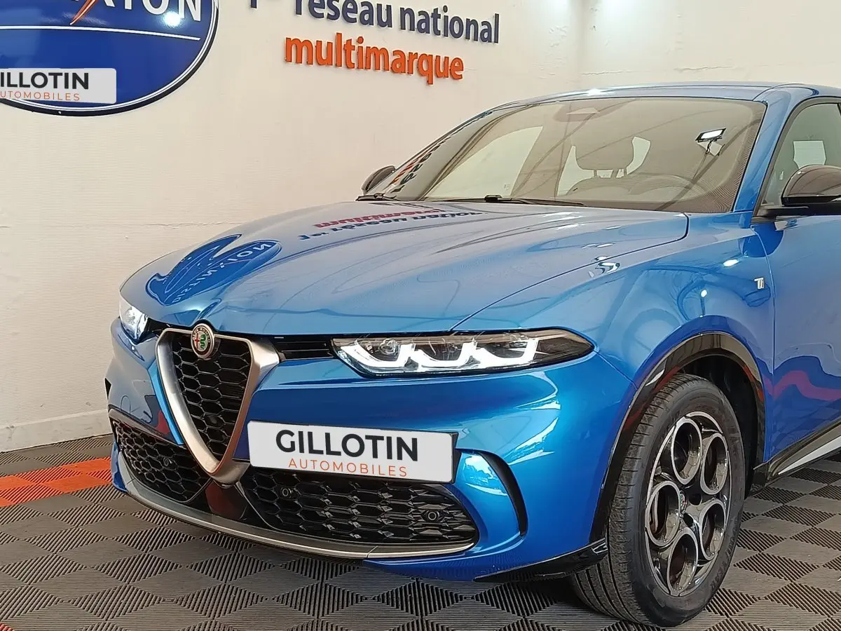 Vue 3/4 avant droite d'une Alfa Romeo Tonale 1.5T Hybrid 160 VGT bleu avec calandre caractéristique et jantes distinctives.