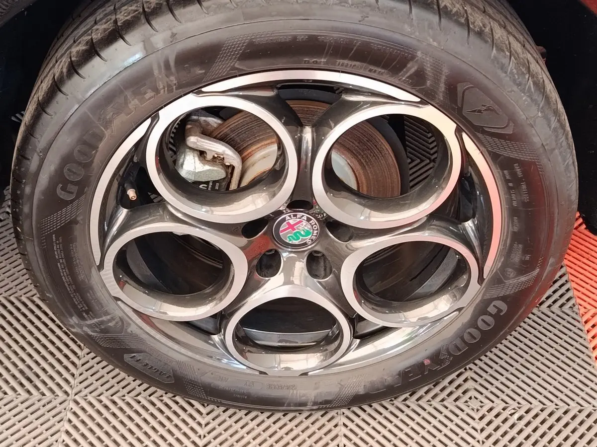Gros plan sur la roue avant droite de l'Alfa Romeo Tonale bleu, avec jante alliage et pneu Goodyear visible.