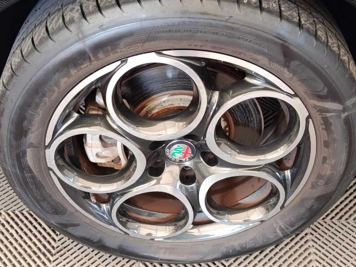 Gros plan sur la jante alu à cinq cercles de l'Alfa Romeo Tonale 1.5T Hybrid 160 VGT avec logo central coloré.