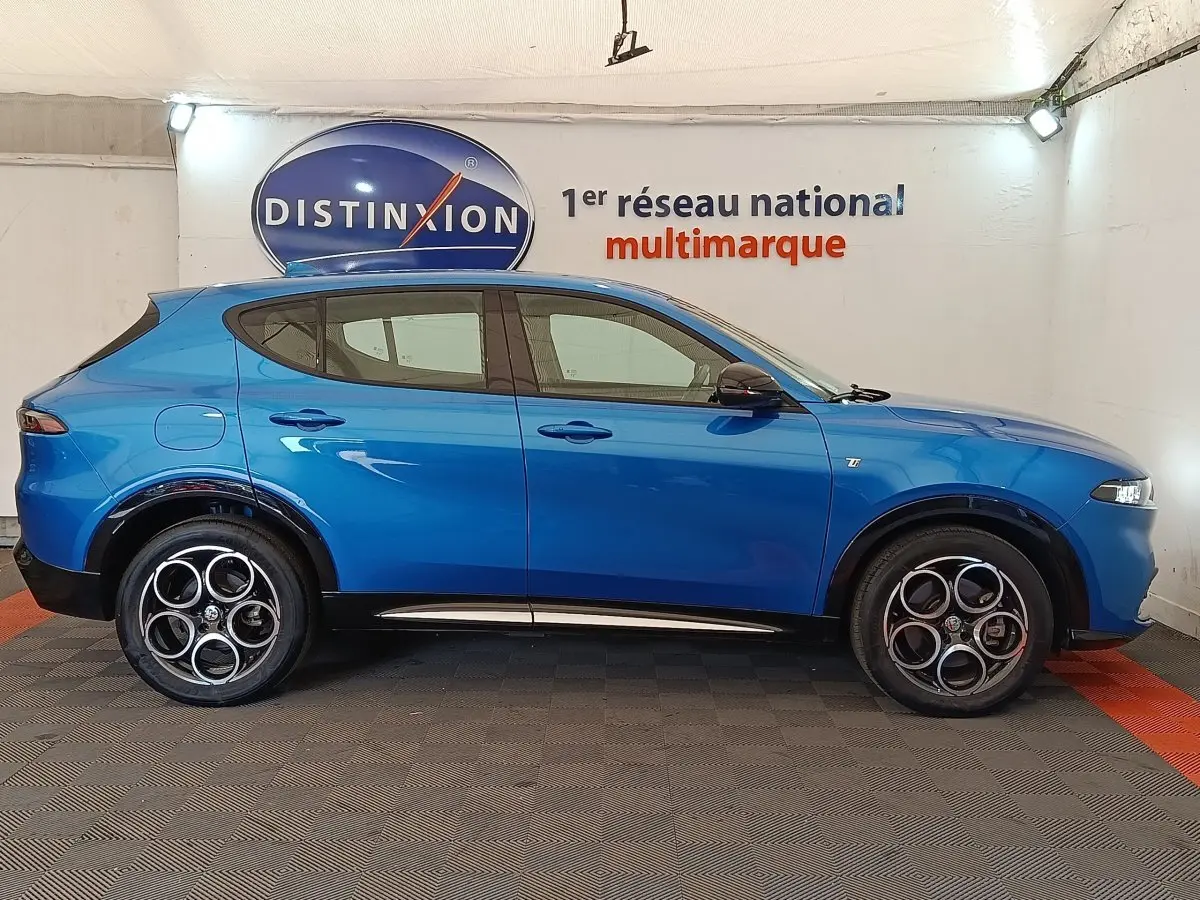 Vue de profil côté gauche de l'Alfa Romeo Tonale 1.5T Hybrid 160 bleu, avec jantes distinctives à cinq cercles.