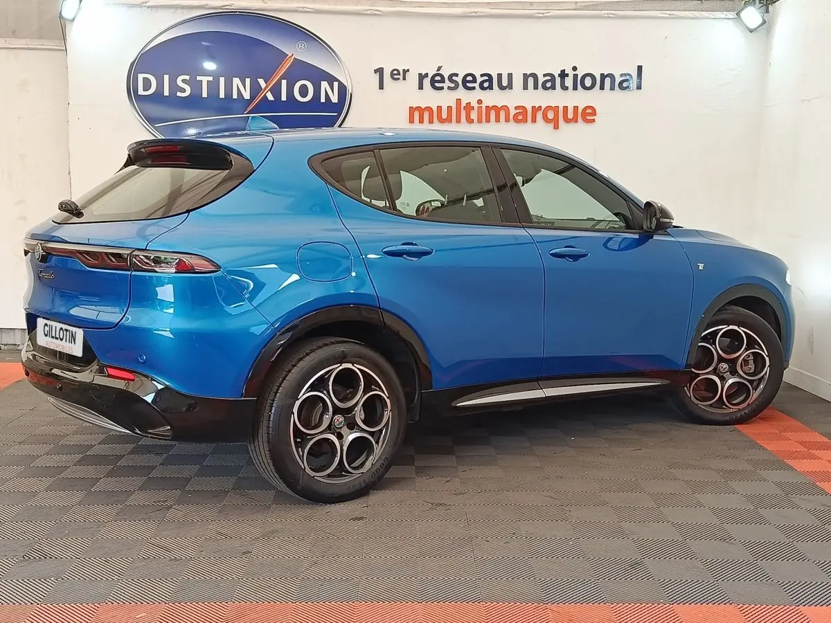Vue 3/4 arrière droite d'une Alfa Romeo Tonale 1.5T Hybrid 160 VGT bleu avec jantes distinctives en alliage.
